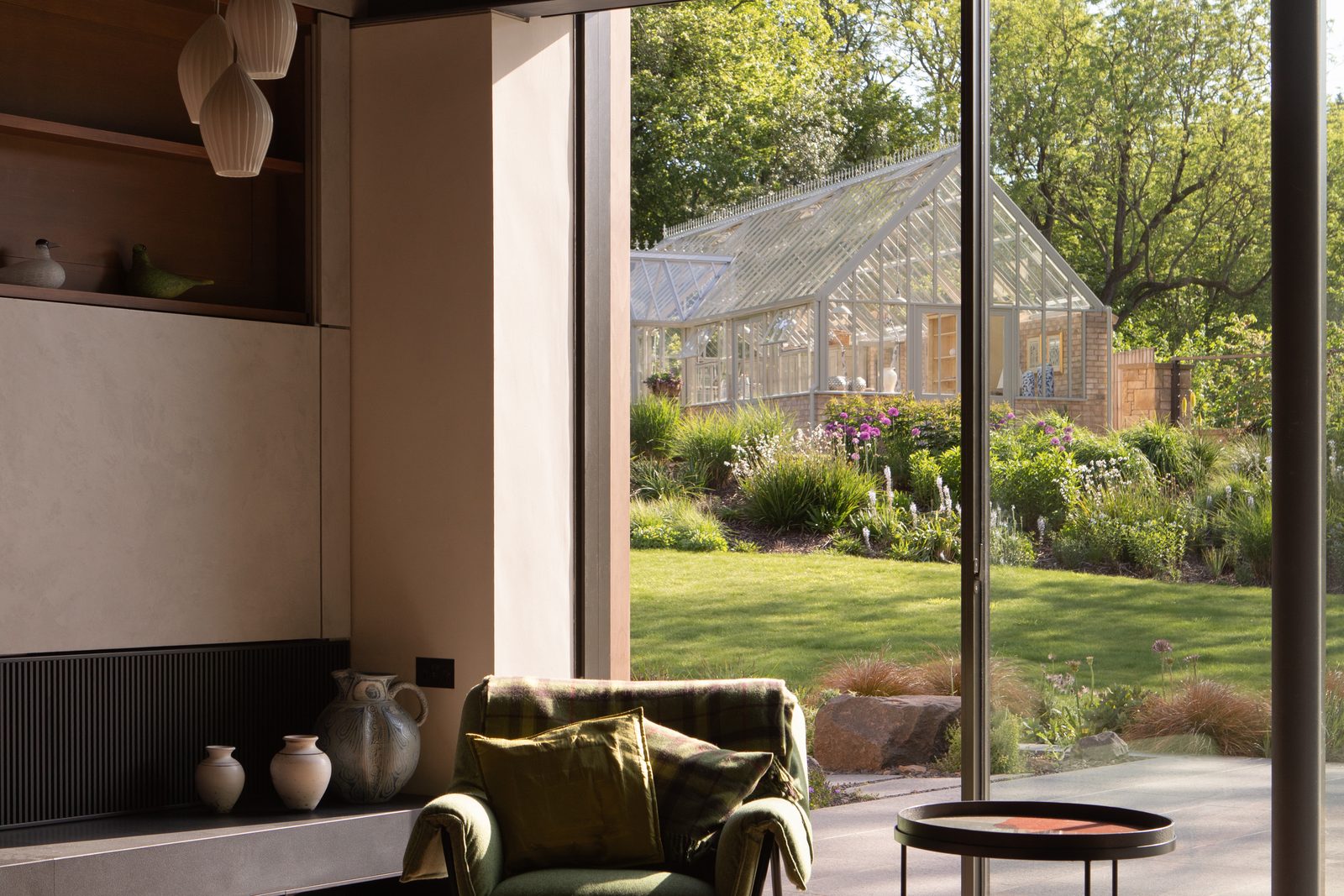 Sitting room designed by Seonaid Johnston, looking out to a garden and Victorian greenhouse